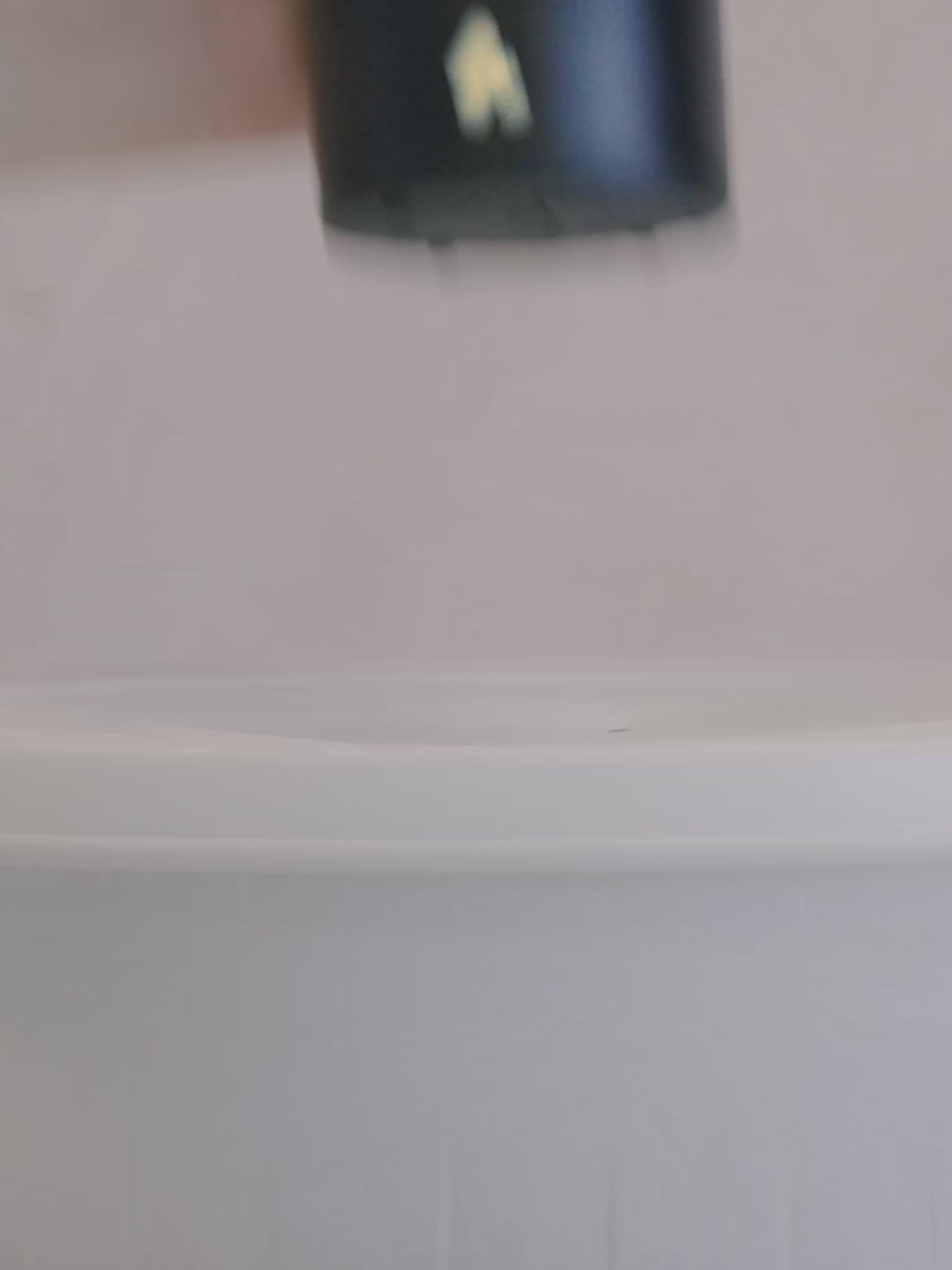 Load video: Video showing a black speaker in motion, the frames show the zoomed in images of the speaker and the passive radiator. It shows a couple using it a forest-like environment hanging from a bag and placing it on the sand with all its accessories as well as how easily the battery lid opens.