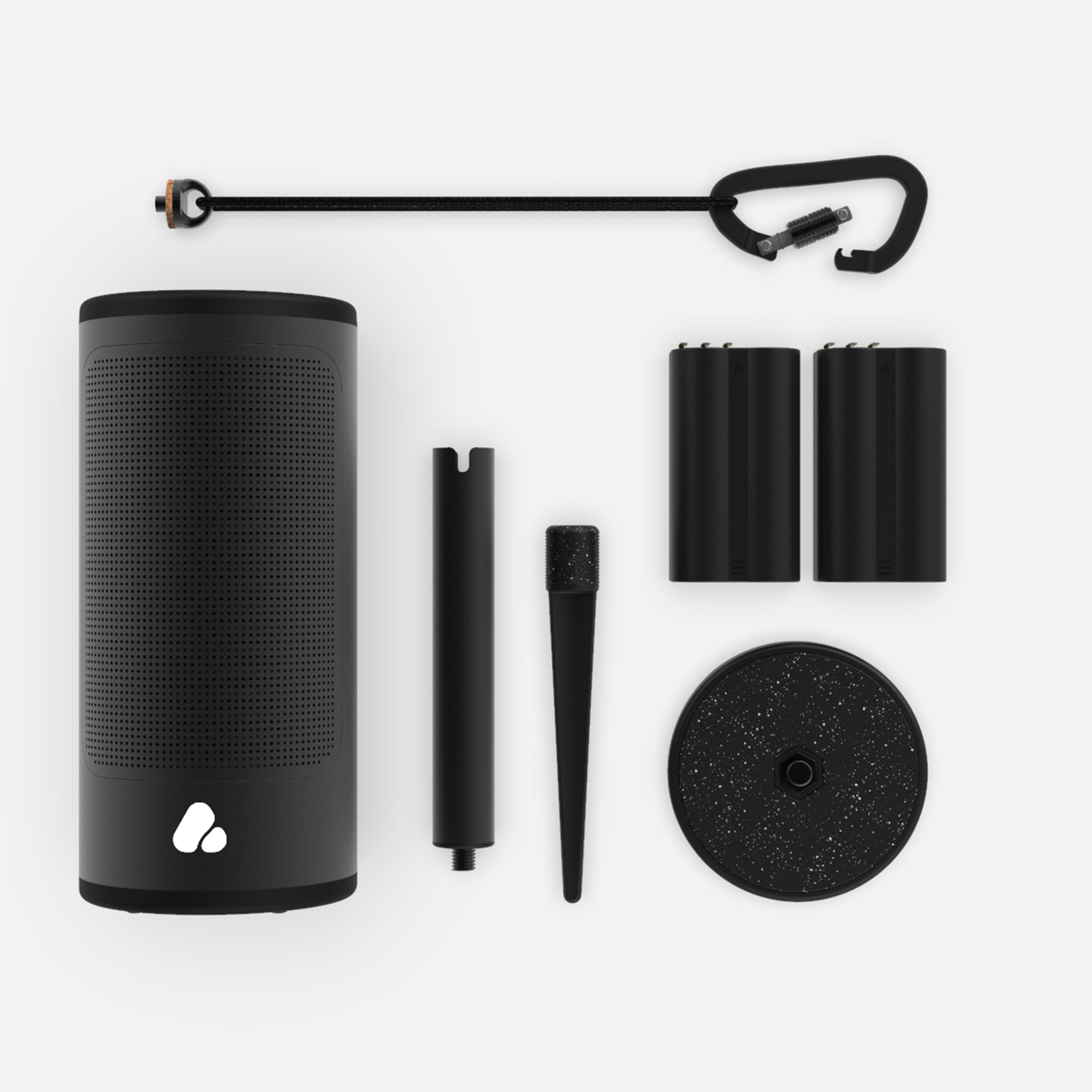 A black cylindrical speaker with an assortment of accessories including a battery, a charging cable, a spike, a stand, and other mounting equipment laid out on a white background.